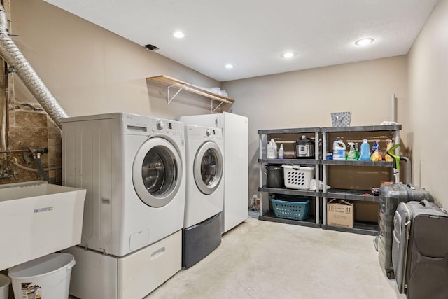 laundry area with washer and dryer, laundry area, recessed lighting, and a sink