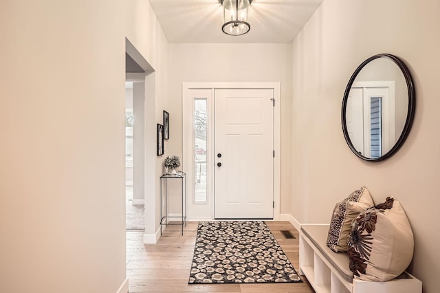 foyer with visible vents, baseboards, and light wood-type flooring