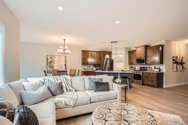 living area featuring recessed lighting, baseboards, a chandelier, and light wood-style floors