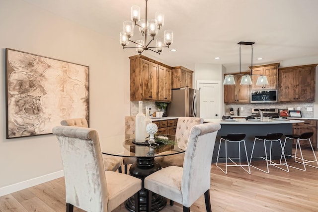 dining area featuring light wood-style floors, recessed lighting, a chandelier, and baseboards