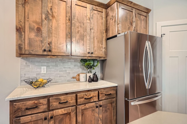 kitchen featuring decorative backsplash and freestanding refrigerator