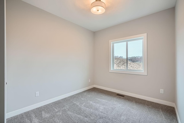 carpeted empty room featuring baseboards and visible vents
