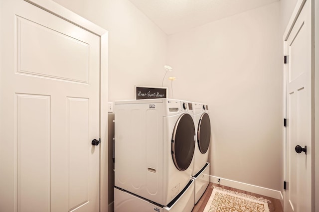 laundry room featuring light wood finished floors, washing machine and clothes dryer, laundry area, and baseboards