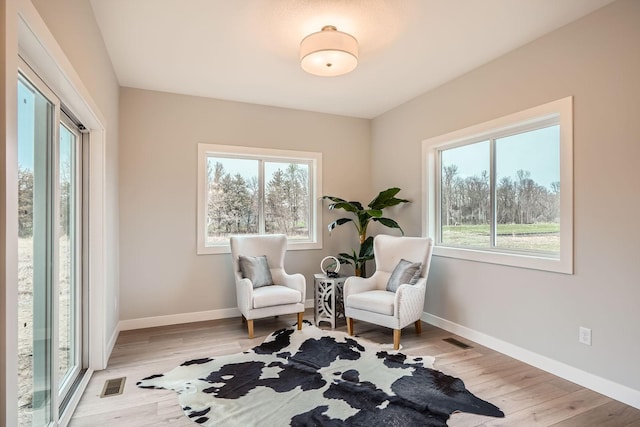 sitting room featuring baseboards, visible vents, and wood finished floors