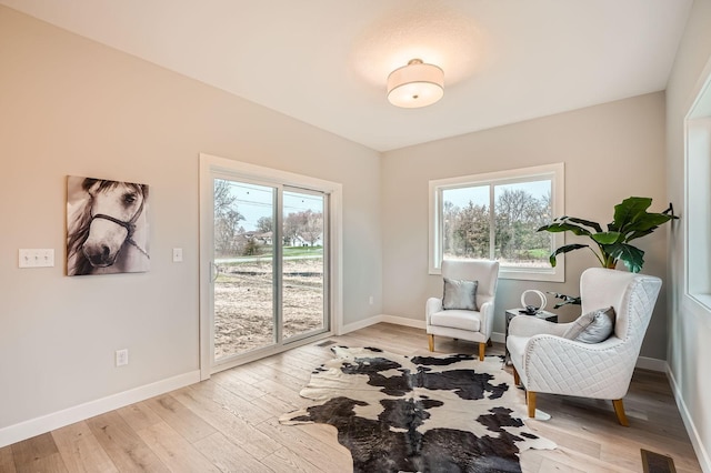 living area with baseboards, visible vents, and light wood-type flooring