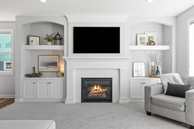 carpeted living room with built in shelves, a fireplace, baseboards, and recessed lighting