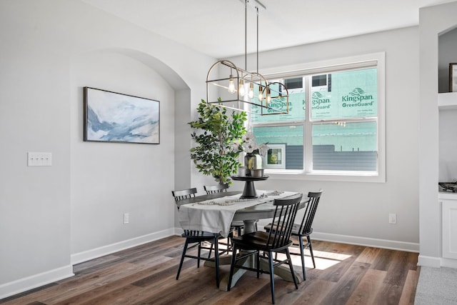 dining space with baseboards and wood finished floors