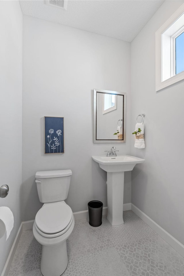 bathroom with a sink, tile patterned flooring, toilet, and baseboards