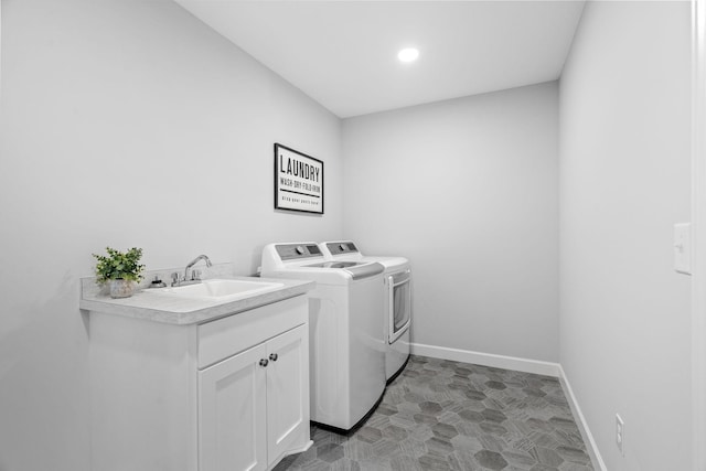 washroom featuring baseboards, a sink, and washing machine and clothes dryer