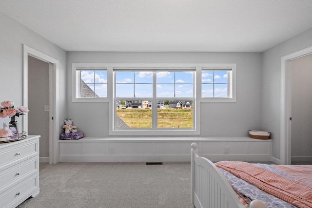 bedroom featuring light colored carpet, visible vents, and multiple windows