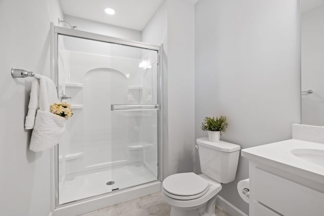 bathroom with a shower stall, toilet, and vanity