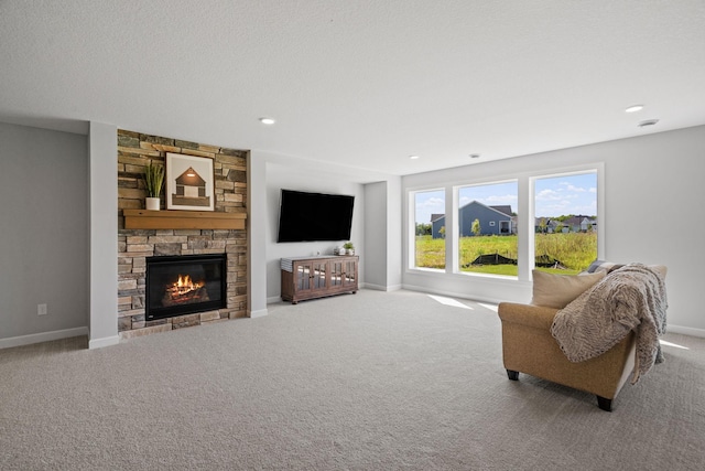 living area featuring recessed lighting, carpet, baseboards, and a stone fireplace