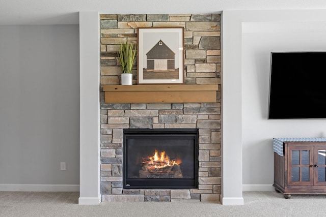 details featuring a stone fireplace, carpet flooring, and baseboards