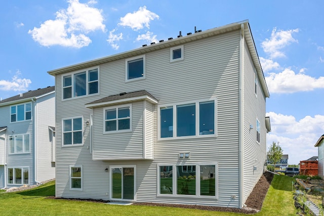 rear view of house featuring a lawn