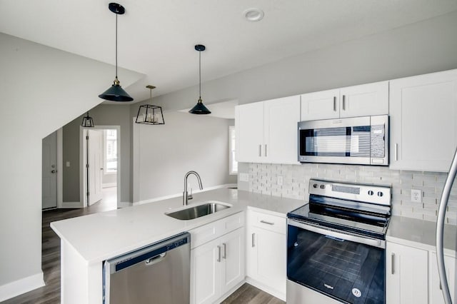 kitchen with sink, white cabinets, appliances with stainless steel finishes, and kitchen peninsula