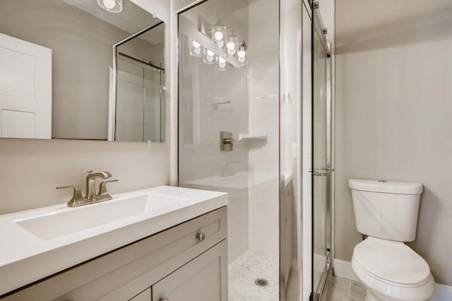 bathroom featuring vanity, a shower with shower door, and toilet