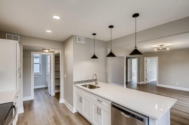 kitchen featuring hanging light fixtures, a kitchen island with sink, sink, white cabinets, and stainless steel appliances