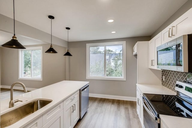 kitchen with sink, stainless steel appliances, white cabinets, and decorative backsplash