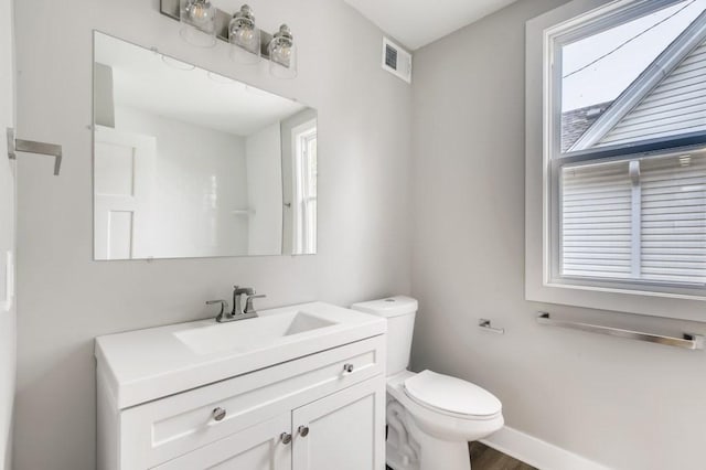 bathroom with hardwood / wood-style flooring, toilet, and vanity