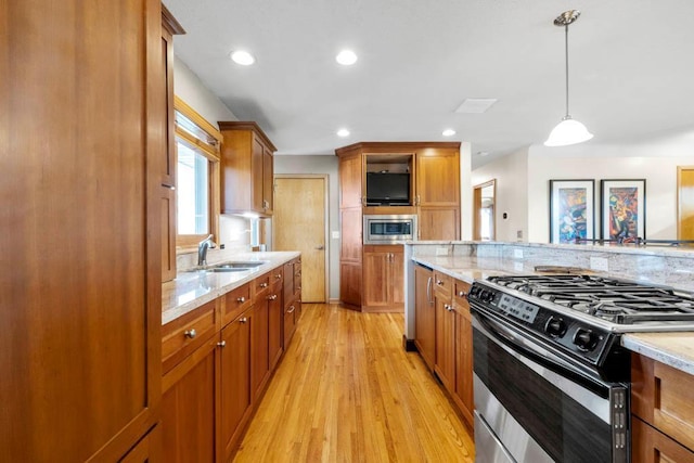 kitchen with a sink, appliances with stainless steel finishes, and brown cabinetry