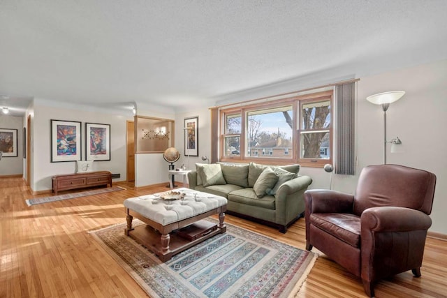 living room featuring a textured ceiling and light wood-style flooring