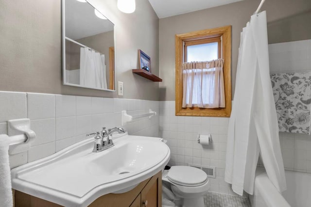 full bath featuring vanity, visible vents, wainscoting, tile walls, and toilet