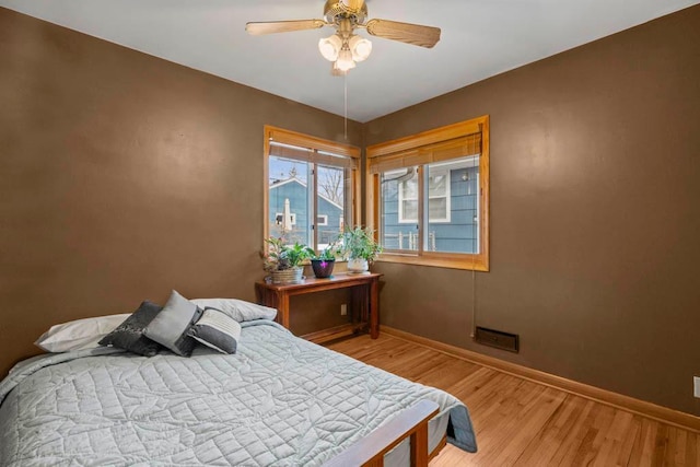 bedroom with baseboards, a ceiling fan, and light wood finished floors