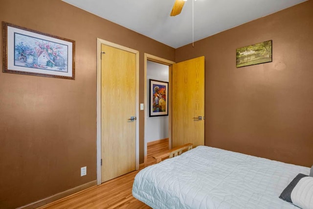 bedroom with light wood finished floors, baseboards, and ceiling fan