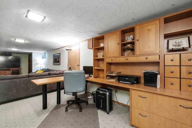 home office featuring built in desk and light colored carpet