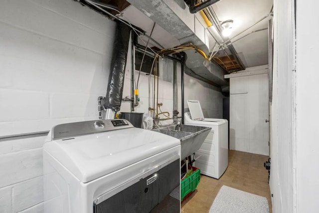 laundry area featuring concrete block wall, independent washer and dryer, and laundry area