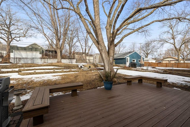 snow covered deck featuring a residential view, an outdoor structure, and fence