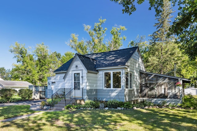 bungalow-style home with a front lawn and a sunroom