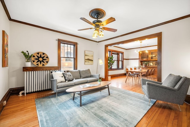 living room with ornamental molding, radiator, and light hardwood / wood-style floors