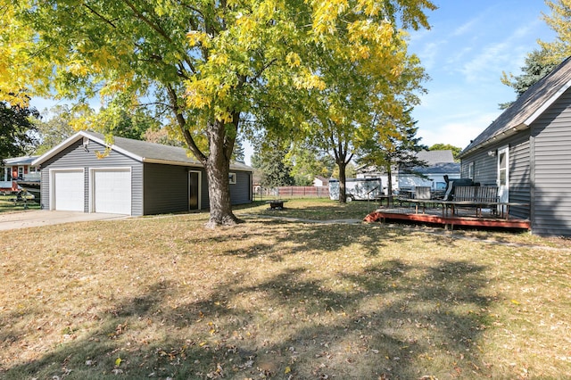 view of yard with a garage, an outdoor structure, and a deck