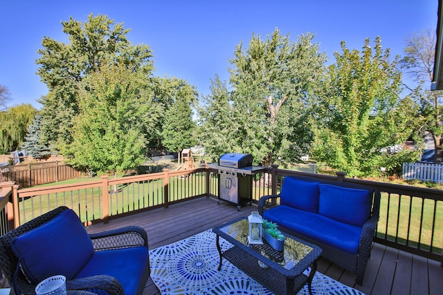 wooden deck featuring a yard, a playground, and a grill