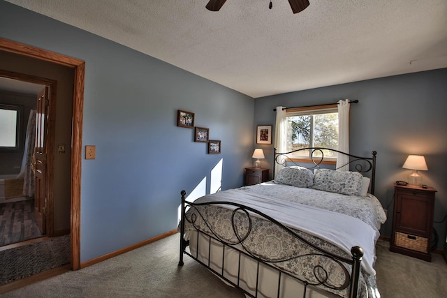 carpeted bedroom featuring a textured ceiling and ceiling fan