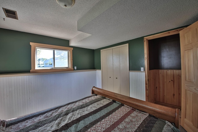 unfurnished bedroom with a textured ceiling and a closet