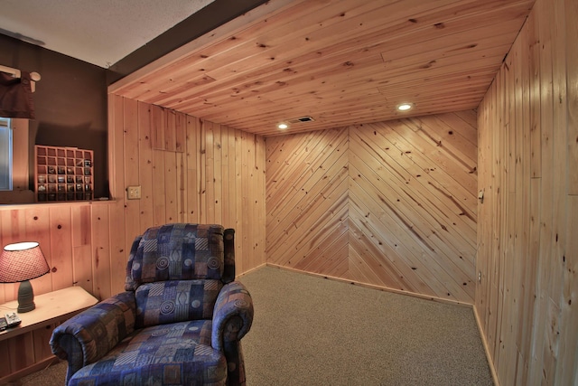 sitting room with carpet flooring, wood ceiling, and wooden walls