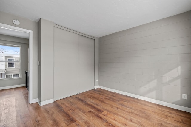 unfurnished bedroom with hardwood / wood-style flooring and a closet