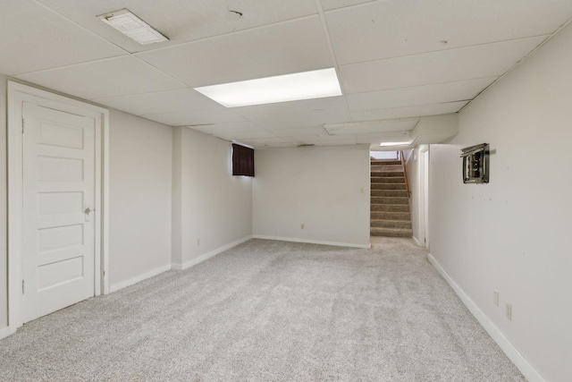 basement featuring light colored carpet and a drop ceiling