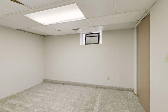 basement featuring a drop ceiling and carpet floors