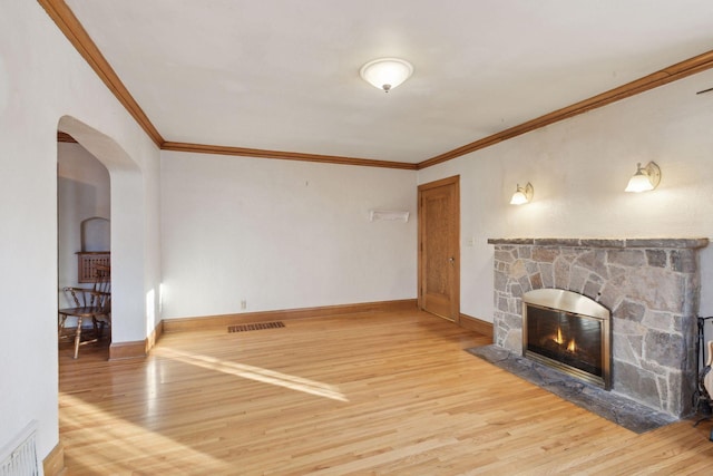 unfurnished living room with ornamental molding, a fireplace, and wood-type flooring