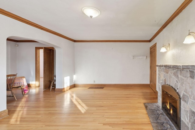 living room with hardwood / wood-style flooring, ornamental molding, and a fireplace