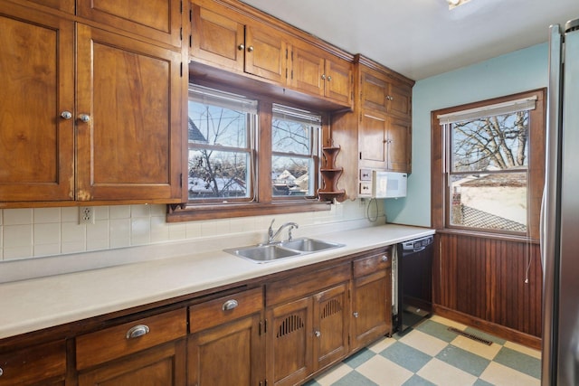 kitchen with sink, black dishwasher, plenty of natural light, and stainless steel fridge