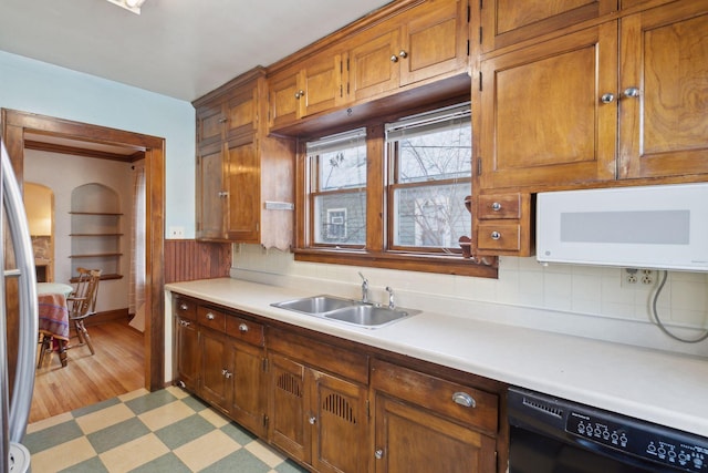 kitchen with sink, stainless steel fridge, and black dishwasher