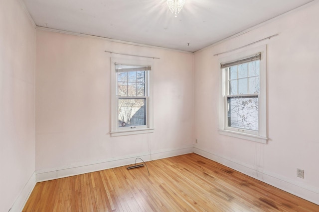 unfurnished room with hardwood / wood-style flooring, ornamental molding, and plenty of natural light