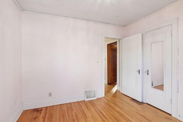 unfurnished bedroom featuring crown molding and light hardwood / wood-style floors