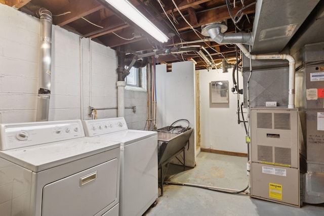 clothes washing area with separate washer and dryer, heating unit, and sink