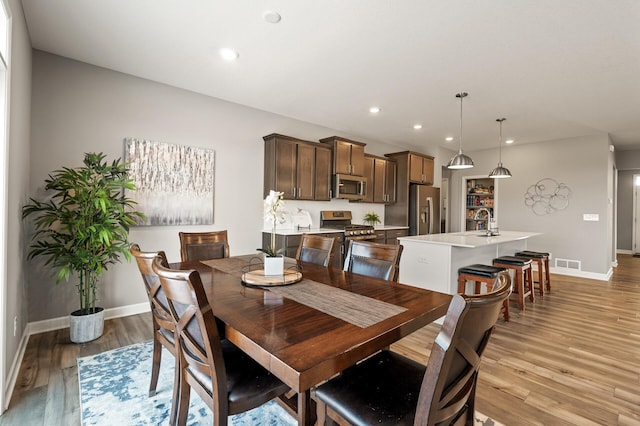 dining area featuring sink and light wood-type flooring