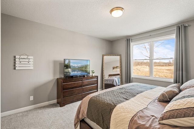 bedroom with light colored carpet and a textured ceiling